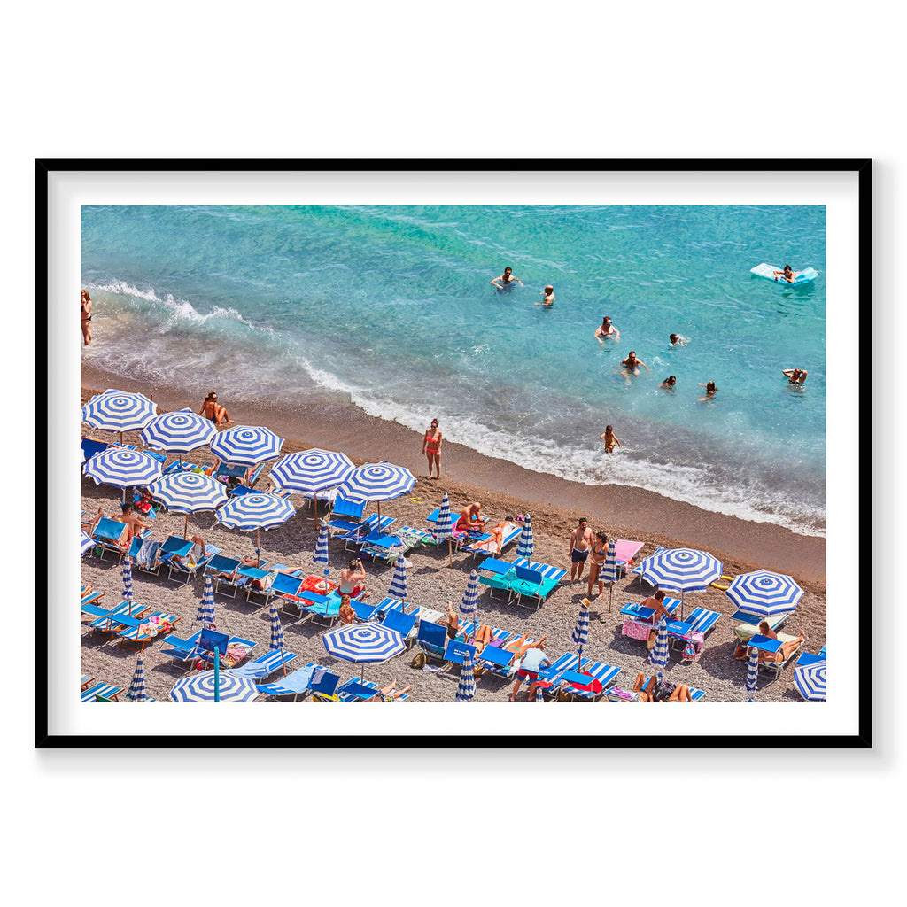 Aerial view of Positano beach with blue umbrellas, swimmers and turquoise water, Amalfi Coast, photography print by Remy G...