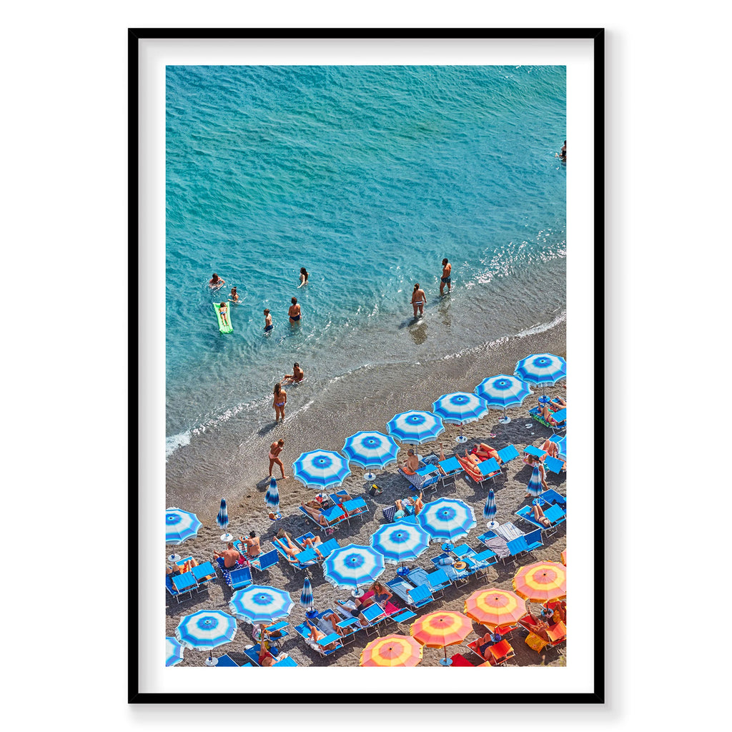 Aerial view of Positano beach with blue and yellow umbrellas, swimmers and turquoise water, photography print by Remy Gerega