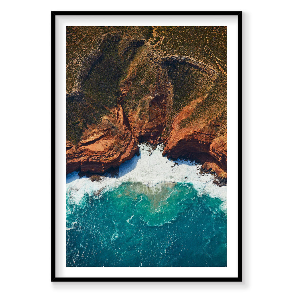 Aerial view of turquoise waves crashing against jagged red cliffs at Kalbarri, photography print by Remy Gerega