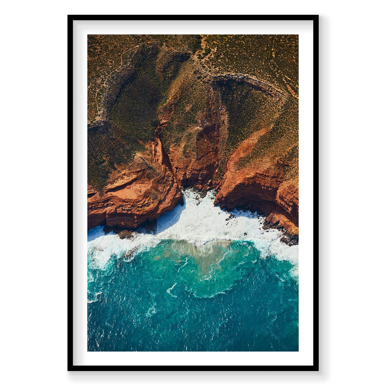 Aerial view of turquoise waves crashing against jagged red cliffs at Kalbarri, photography print by Remy Gerega