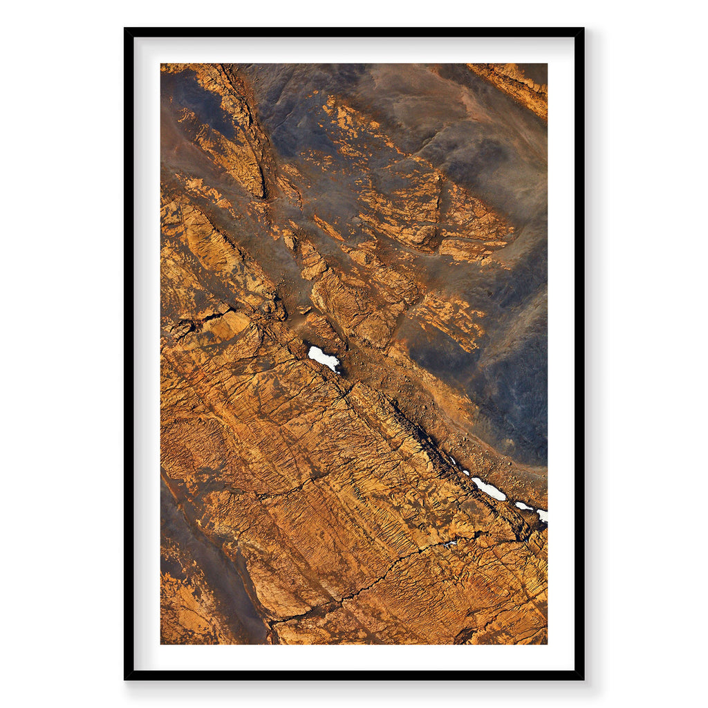 Aerial view of golden Icelandic mountains with snow patches from above, photography print by Remy Gerega