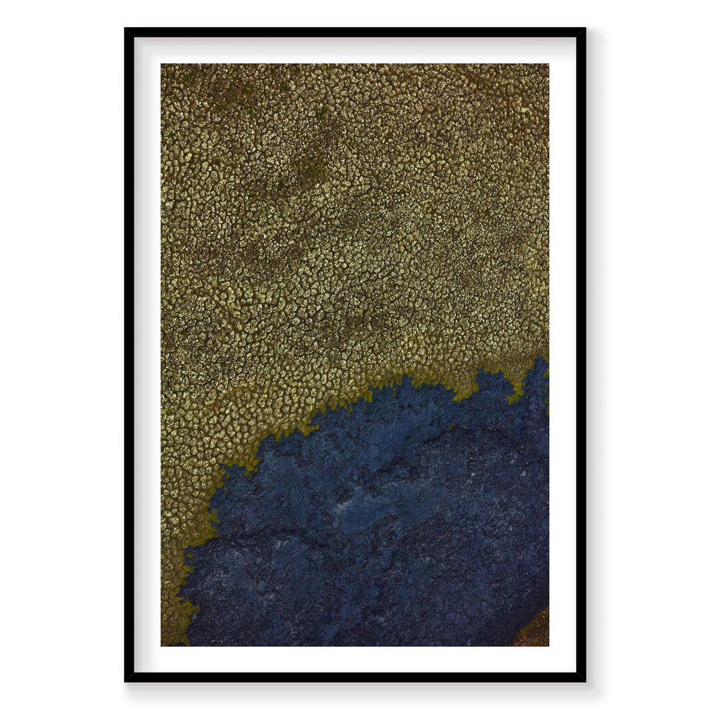 Aerial view of moss-covered Icelandic landscape with dark volcanic rock formations, photography print by Remy Gerega