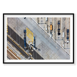 Aerial view of industrial port with blue cargo ships and yellow striped dock, photography print by Remy Gerega