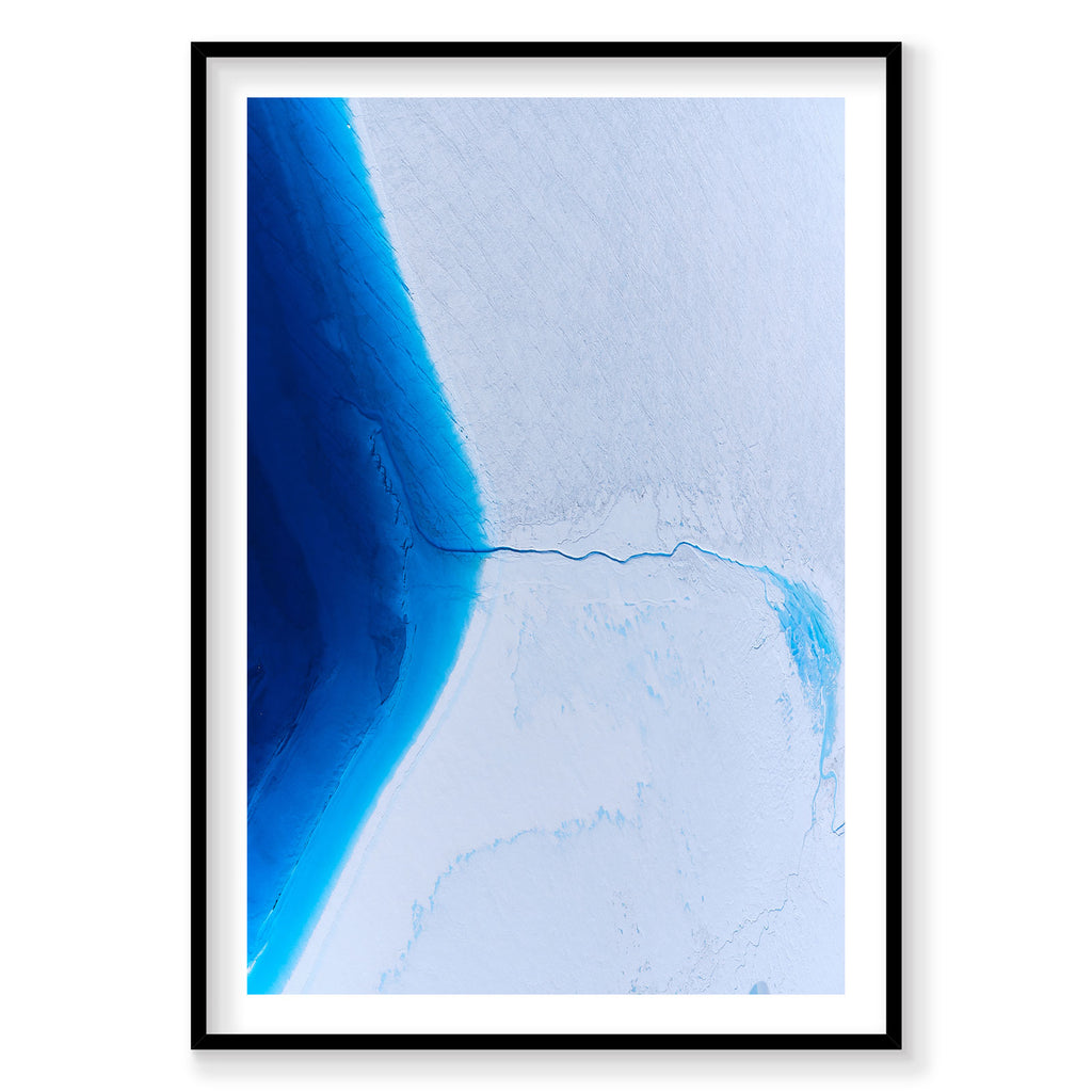 Aerial view of vibrant blue glacial ice sheet meeting white snow in Greenland from above, photography print by Remy Gerega