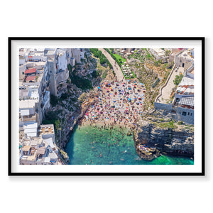 Aerial view of Polignano a Mare beach cove with turquoise water and crowded sandy beach, photography print by Remy Gerega