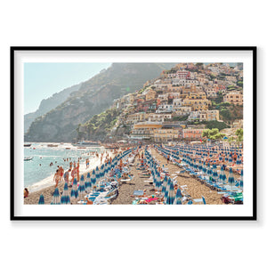 Positano beach with blue umbrellas and colorful cliffside village, Italy, photography print by Remy Gerega