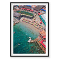 Aerial view of Bagni Internazionali Capri with colorful umbrellas and people in the water, framed artwork.