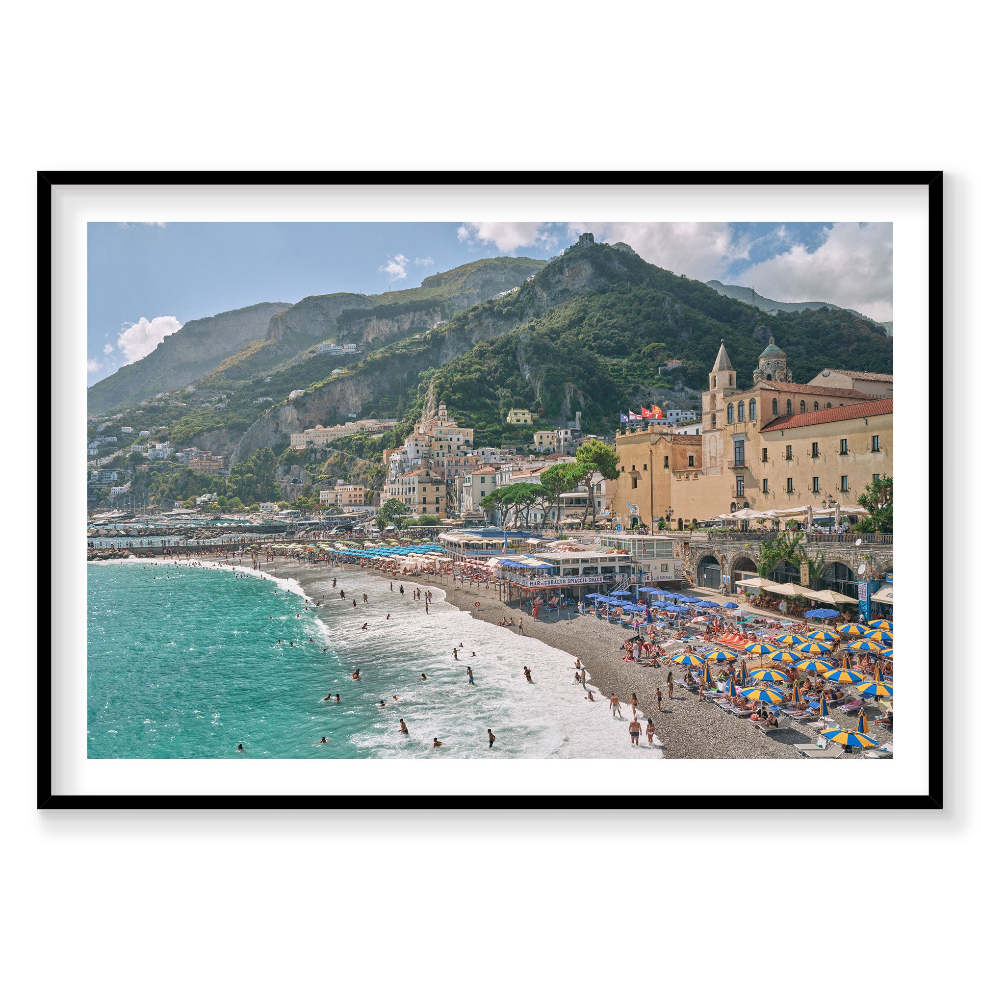 Amalfi Coast beach with turquoise waters, colorful umbrellas, and hillside village, photography print by Remy Gerega