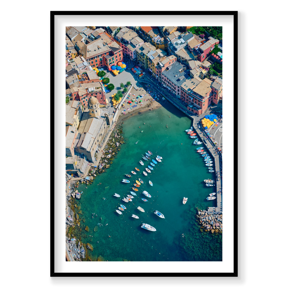 Overhead view of colourful waterfront buildings, a small beach, boats and swimmers in Vernazza harbour, Cinque Terre, Italy, black frame.