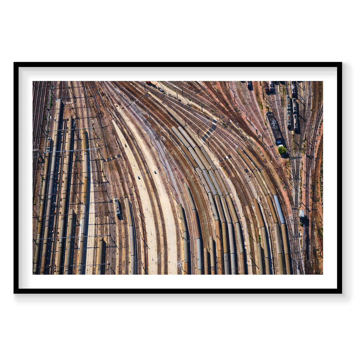 Aerial view of curving railway tracks and rows of train carriages in a rail yard in the Paris region, France; black frame