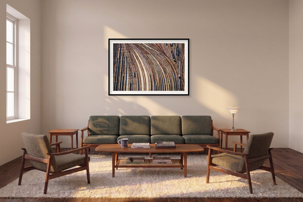 Aerial view of curving railway tracks and rows of train carriages in a rail yard in the Paris region, France; black framed print in a room setting