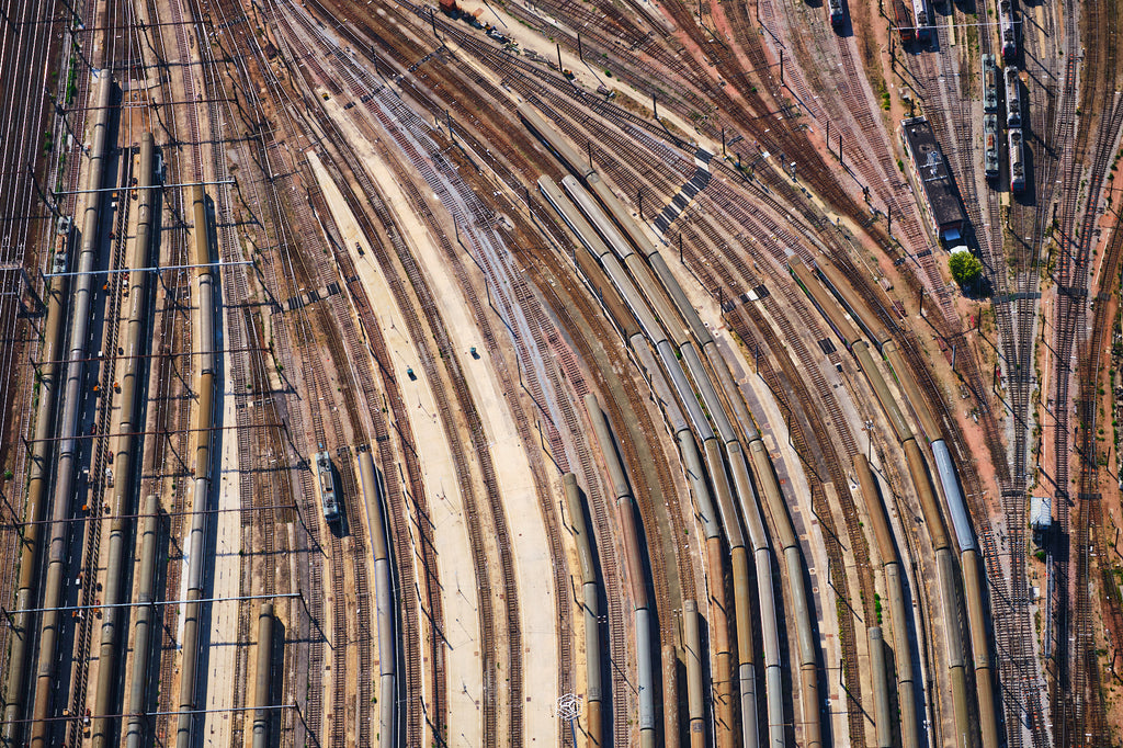 Aerial view of curving railway tracks and rows of train carriages in a rail yard in the Paris region, France; print only