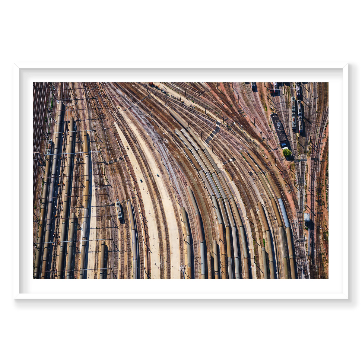 Aerial view of curving railway tracks and rows of train carriages in a rail yard in the Paris region, France; white frame