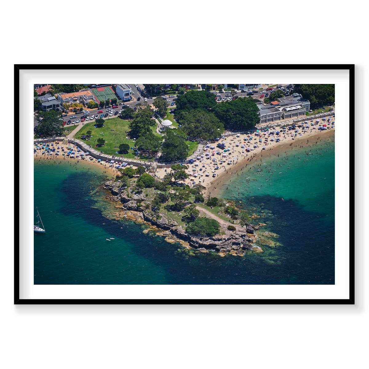 Balmoral Beach in Sydney, with swimmers, beach shelters and a rocky point, shown in a black frame.