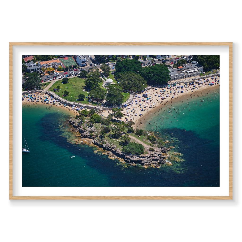 Balmoral Beach photograph with green shallows and a rocky point, shown in a natural timber frame.