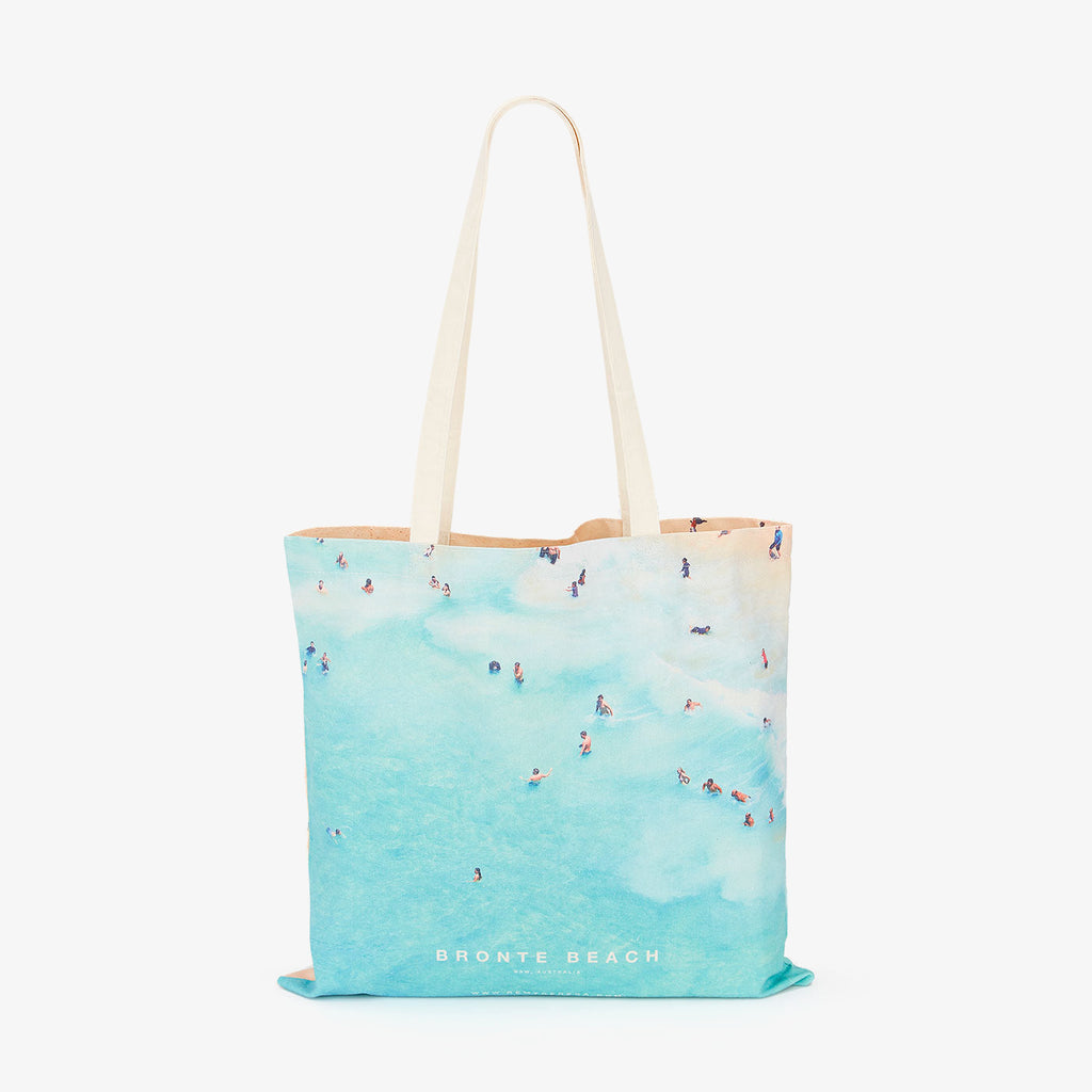 Aerial view of Bronte Beach with swimmers in turquoise water, canvas tote bag by Remy Gerega