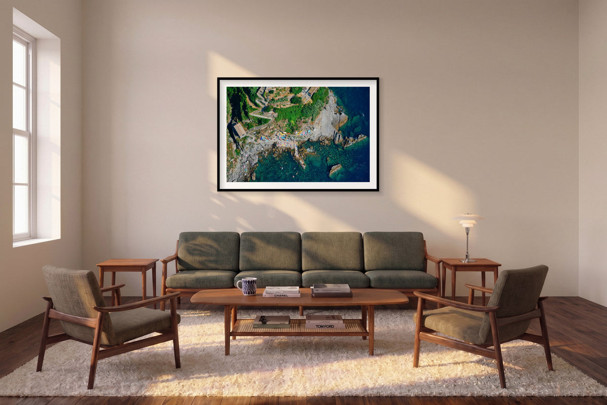 Down to the Sea, Corniglia horizontal photograph in a black frame above a sofa in the room mockup.