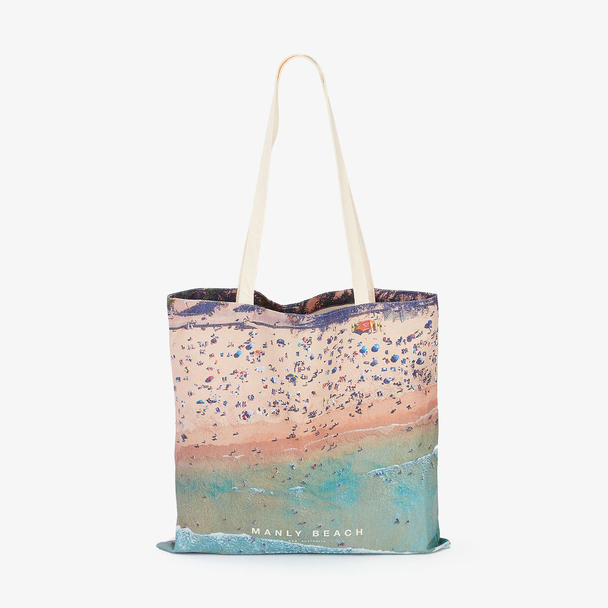 Aerial view of Manly Beach with crowded sandy shore and turquoise water, canvas tote bag by Remy Gerega