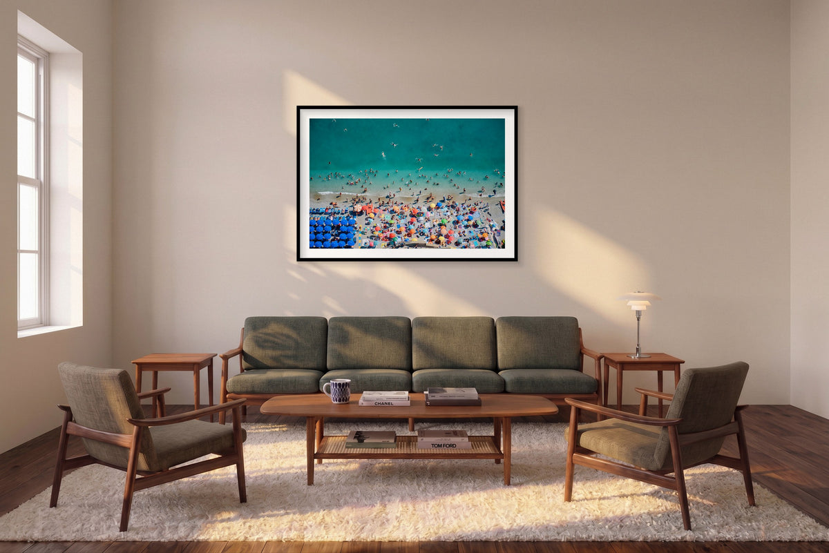Meet Me in the Water, Monterosso al Mare horizontal photograph in a black frame above a sofa in the room mockup.