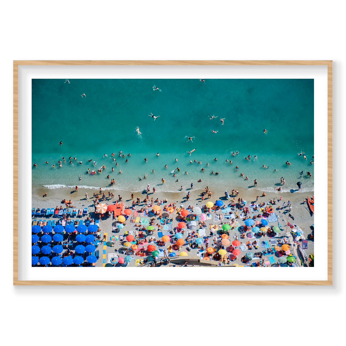 Swimmers in turquoise water beside colourful beach umbrellas at Monterosso al Mare, Cinque Terre, Italy, natural timber frame.