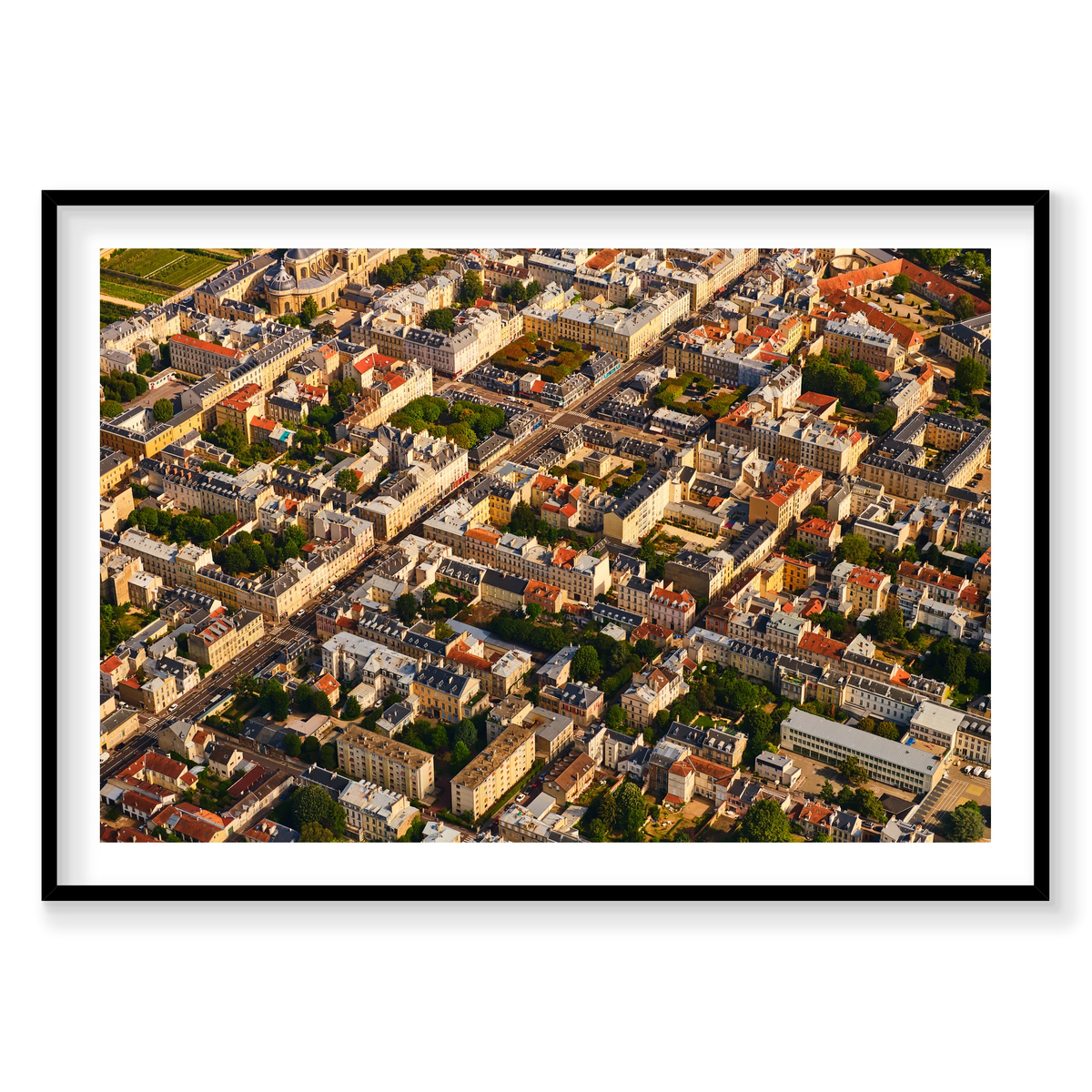 Aerial view of pale buildings, grey and red rooftops, courtyards and tree-lined streets in the Paris region, France; black frame