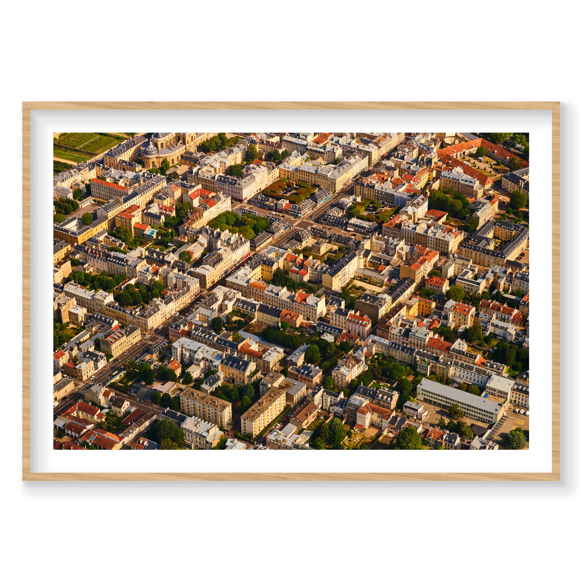 Aerial view of pale buildings, grey and red rooftops, courtyards and tree-lined streets in the Paris region, France; natural timber frame