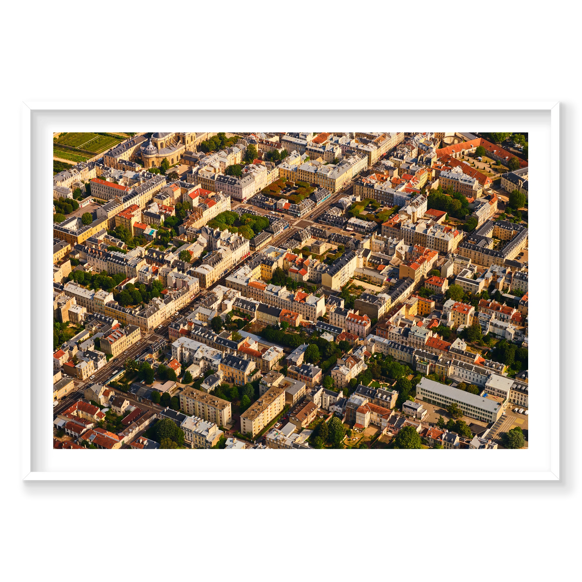 Aerial view of pale buildings, grey and red rooftops, courtyards and tree-lined streets in the Paris region, France; white frame