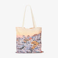 Santorini village sunset view with white buildings and golden domes, canvas tote bag by Remy Gerega.