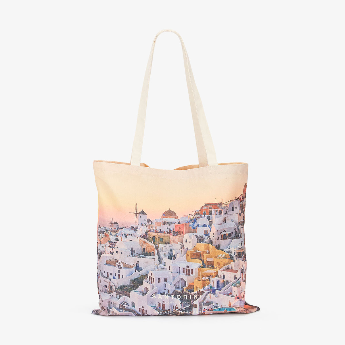 Santorini village sunset view with white buildings and golden domes, canvas tote bag by Remy Gerega.
