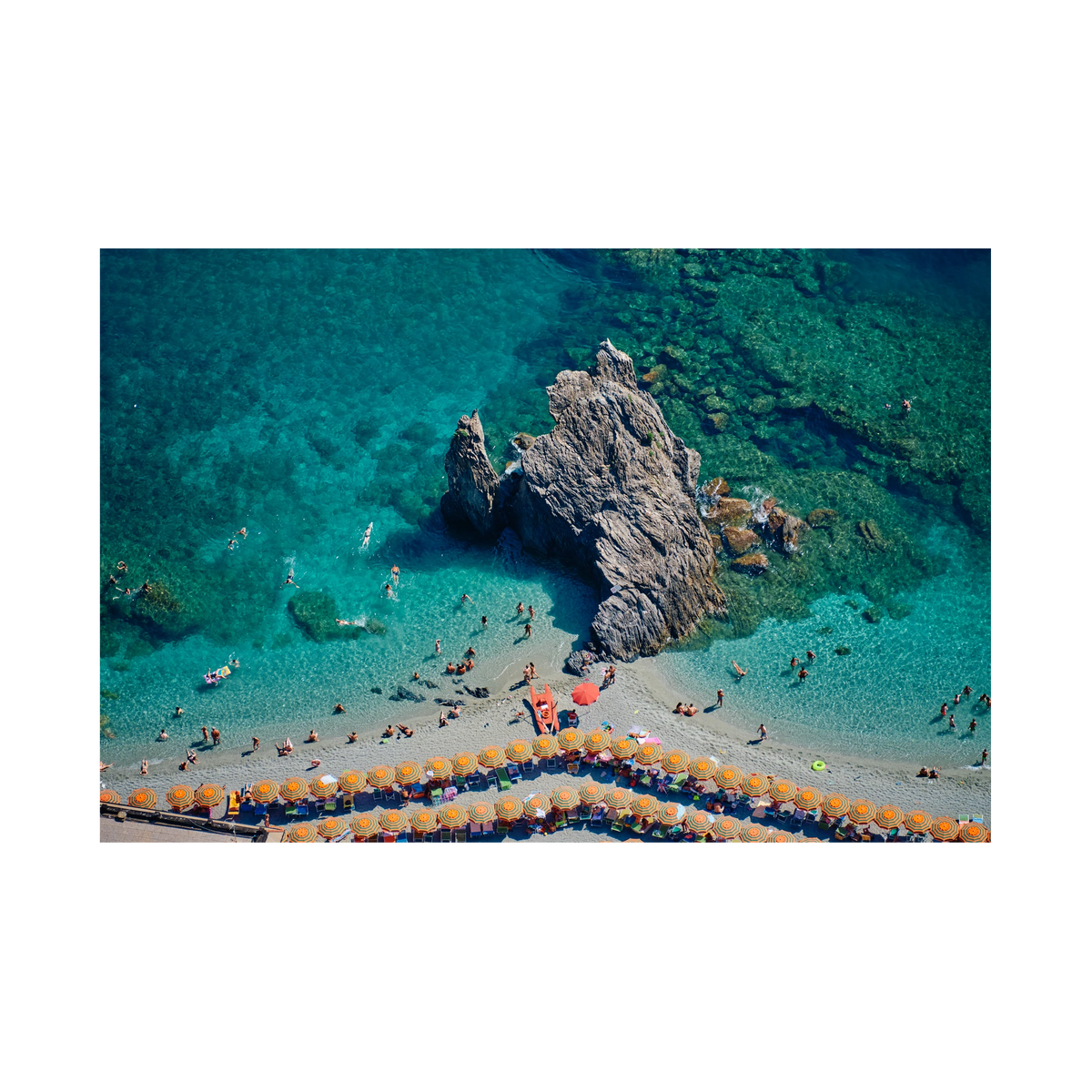 Scoglio di Fegina rock surrounded by swimmers and turquoise water, with orange-striped umbrellas at Monterosso al Mare, Cinque Terre, Italy, print-only presentation.