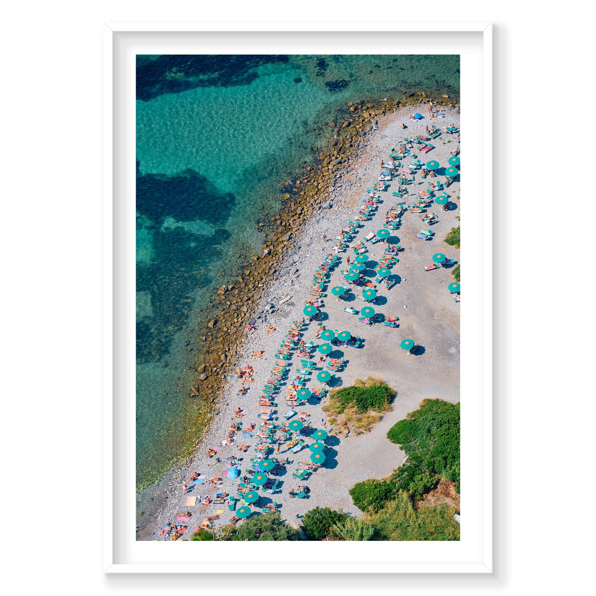 Green umbrellas and sunloungers beside clear water on the pebbled shore of Spiaggia Punta Secco, Palmaria Island, Italy, white frame.