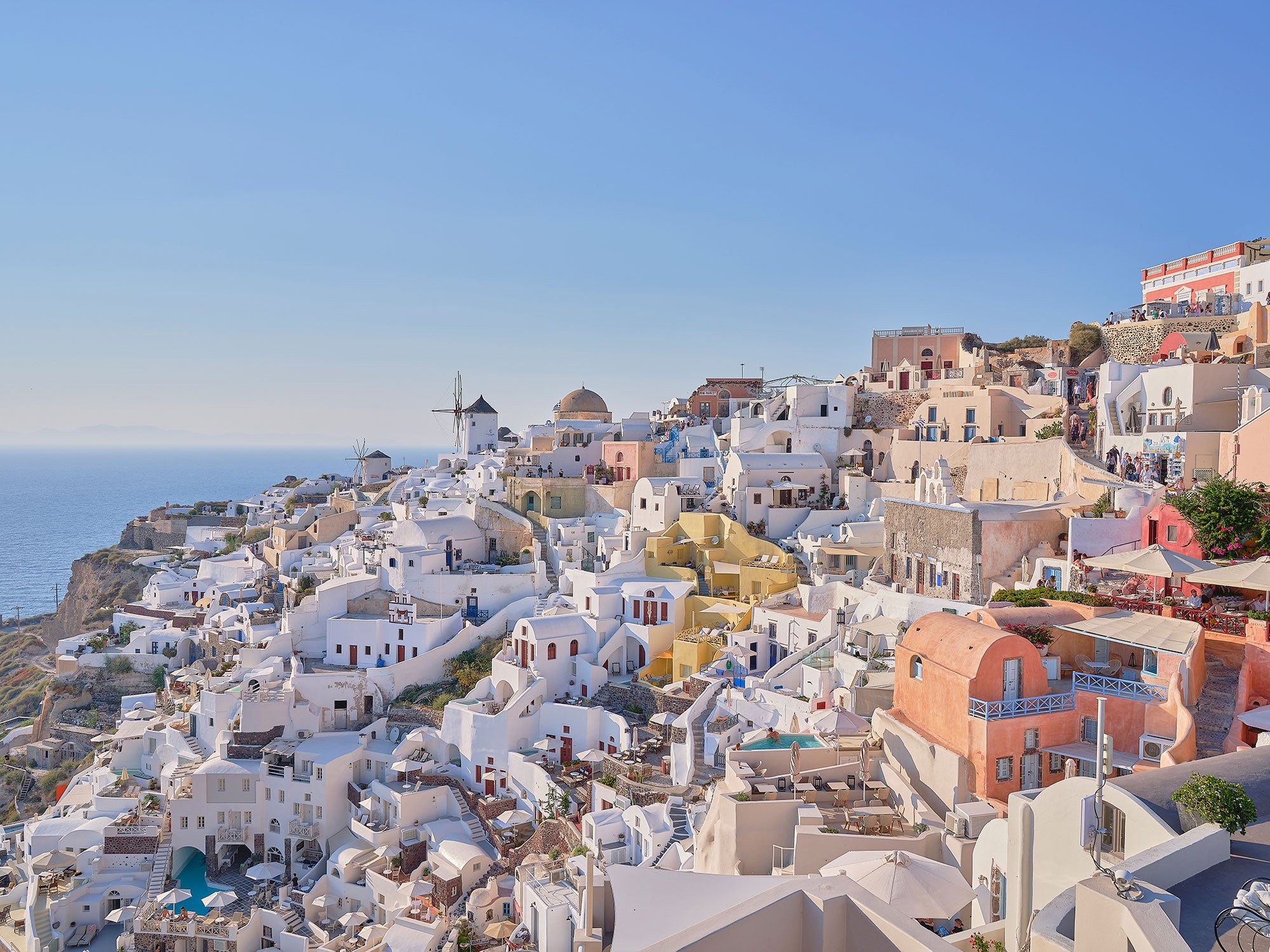 Oia village cliffside with white and colorful buildings overlooking Aegean Sea, photography print by Remy Gerega