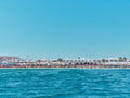 Ornos Beach Mykonos Greece from turquoise waters, white-washed buildings and palm trees, photography print by Remy Gerega