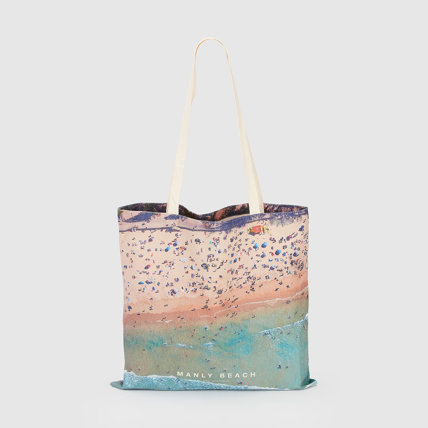 Aerial view of Manly Beach with crowded sandy shore and turquoise water, canvas tote bag by Remy Gerega